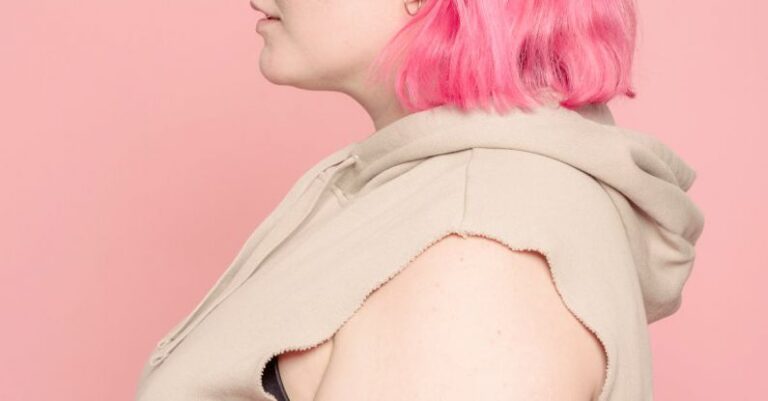 Body Type - Serious young plus size woman in pink studio