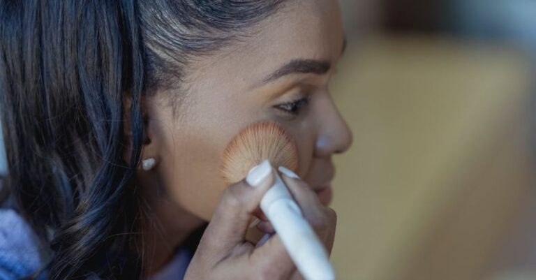 Contouring - Black female applying powder on face