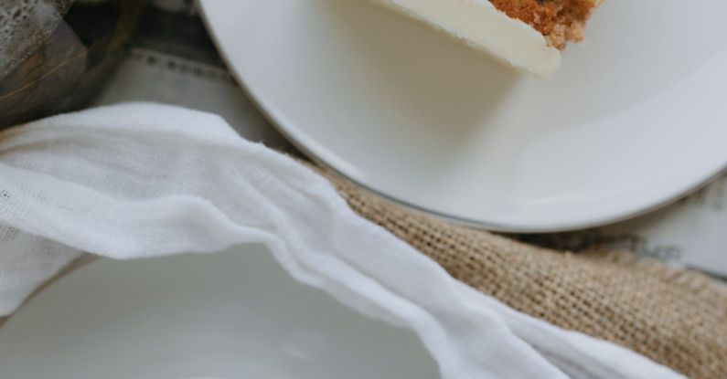 Layering - A white plate with a piece of cake and a cup of tea