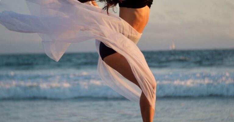 Beauty Practices - Skinny dancer jumping over sandy shore of ocean